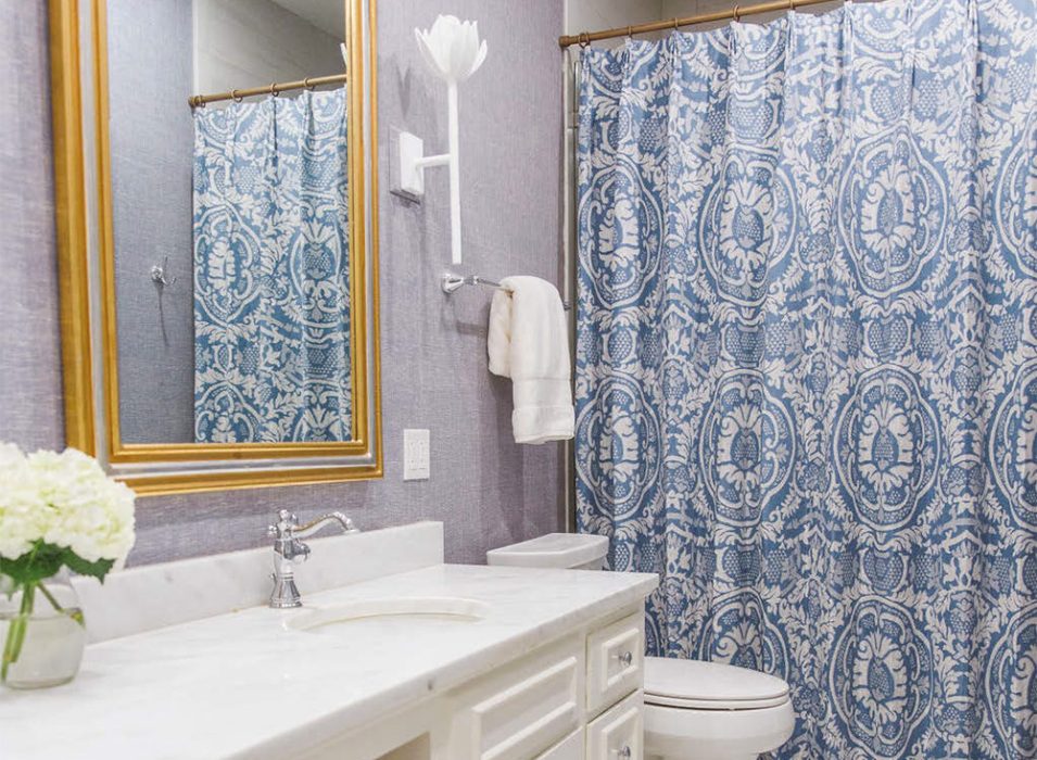 Tall twin mirrors entice the eye upward, and the damask shower curtain brings in a decorative splash. The renovation updated and brightened the space with a crisp white Carrara marble countertop, ceramic tile floors and contemporary wall sconces.