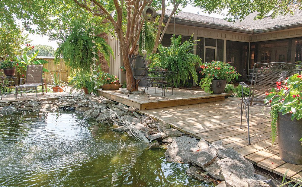 Shaded by mature trees, the backyard is home to lush hanging baskets and potts overflowing with greenery and color every spring and summer.